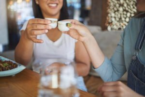 Hands, toast and restaurant with drink, alcohol or friends for congratulations, celebration or part.